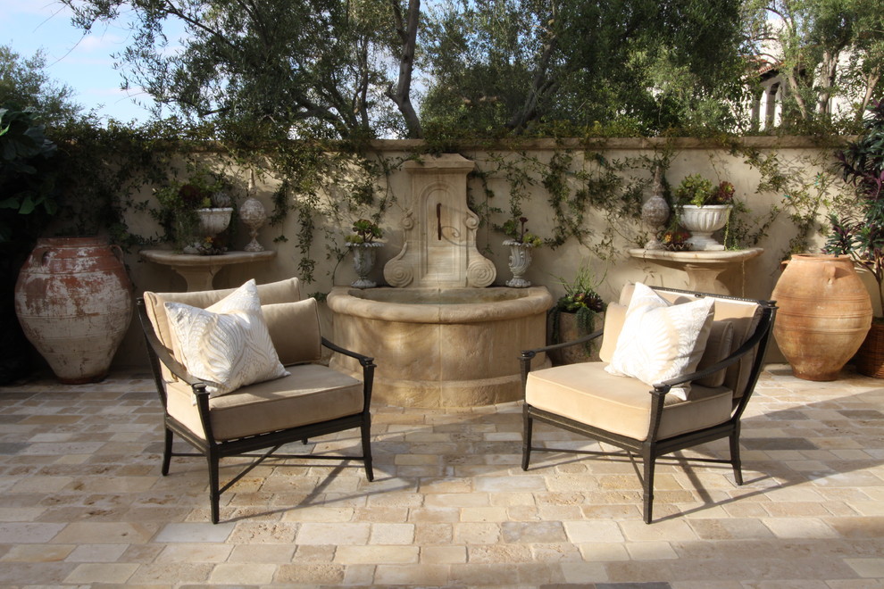 Diseño de patio mediterráneo grande en patio con fuente y adoquines de hormigón