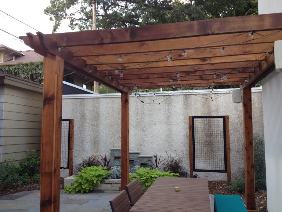 Diseño de patio clásico renovado de tamaño medio en patio trasero con fuente, adoquines de hormigón y pérgola