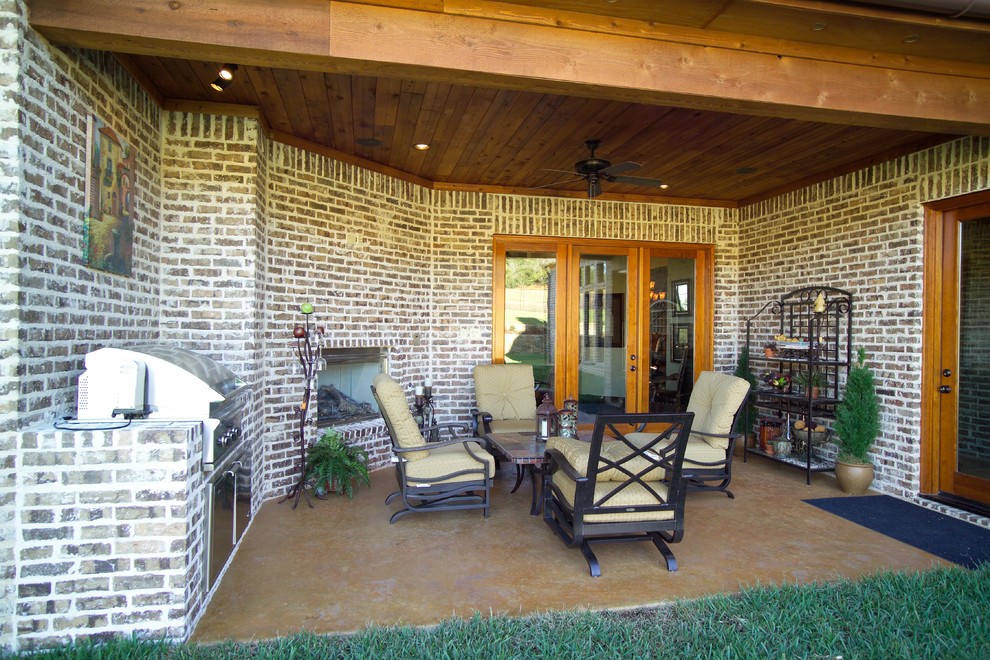 Cette image montre une très grande terrasse arrière traditionnelle avec un foyer extérieur.