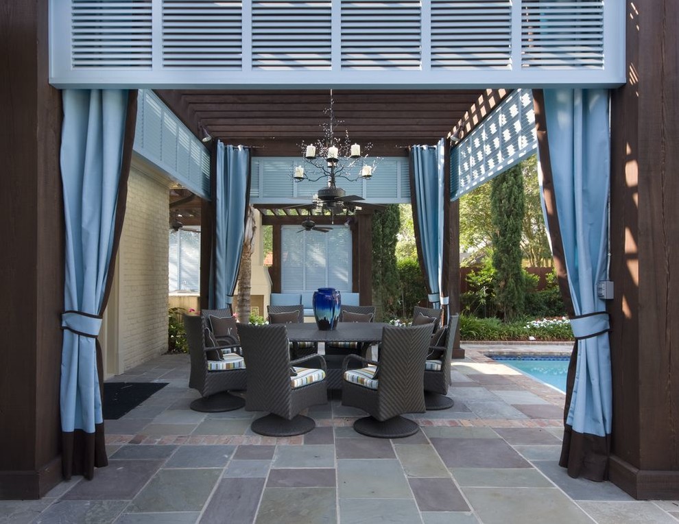 Elegant stone patio photo in New Orleans with a pergola