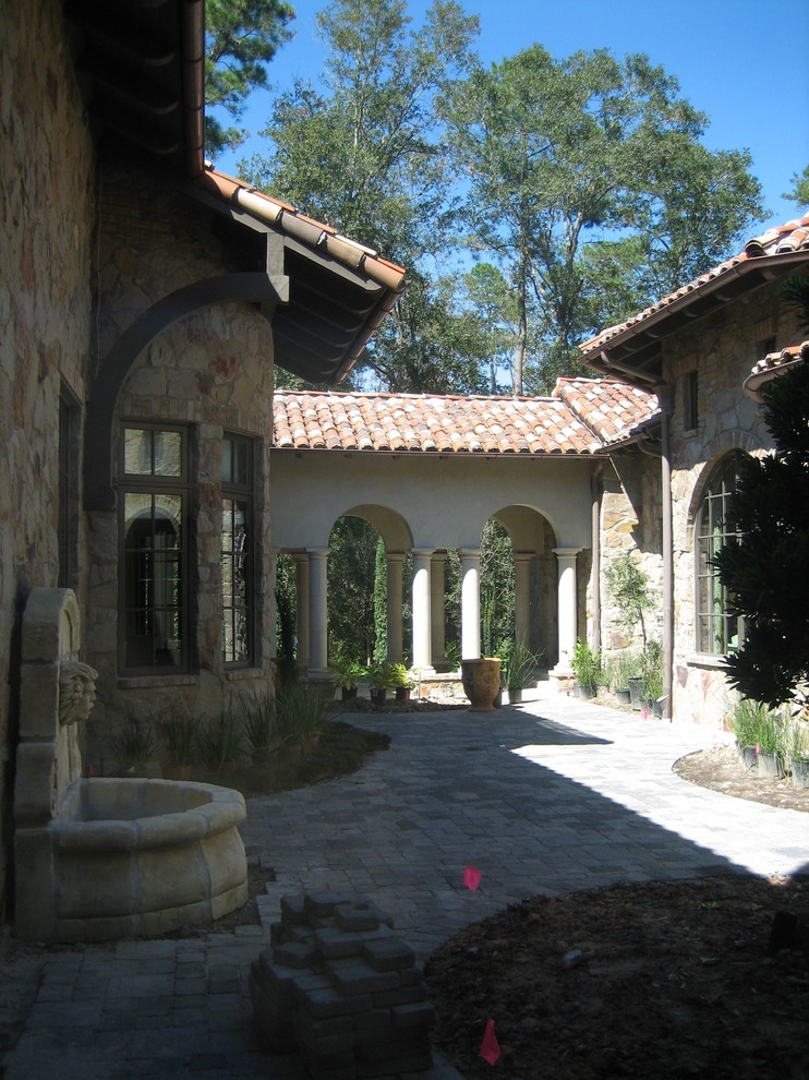 Aménagement d'une terrasse méditerranéenne de taille moyenne avec un point d'eau, une cour, des pavés en brique et aucune couverture.