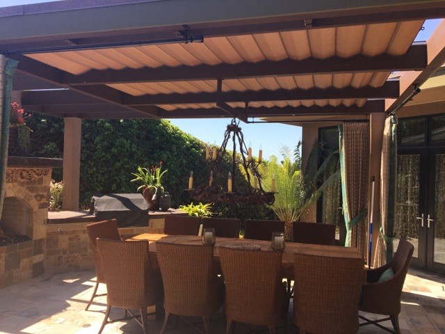 Inspiration for a medium sized mediterranean back patio in San Diego with an outdoor kitchen, natural stone paving and a pergola.