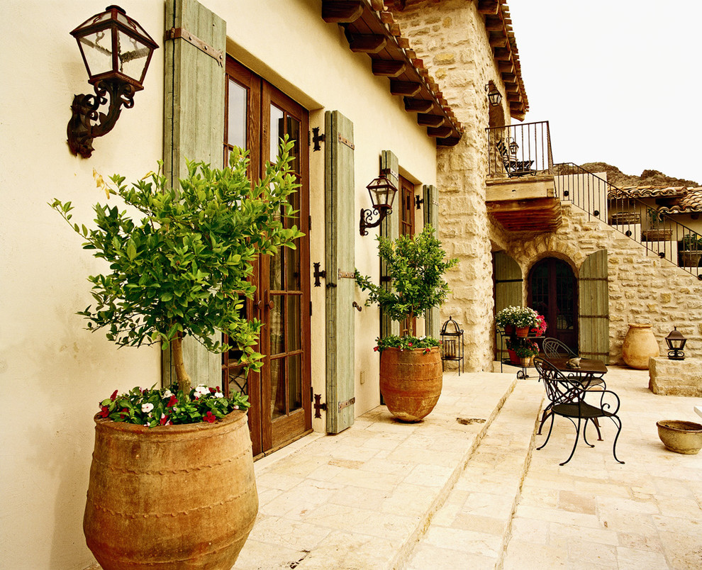 Esempio di un patio o portico mediterraneo con scale