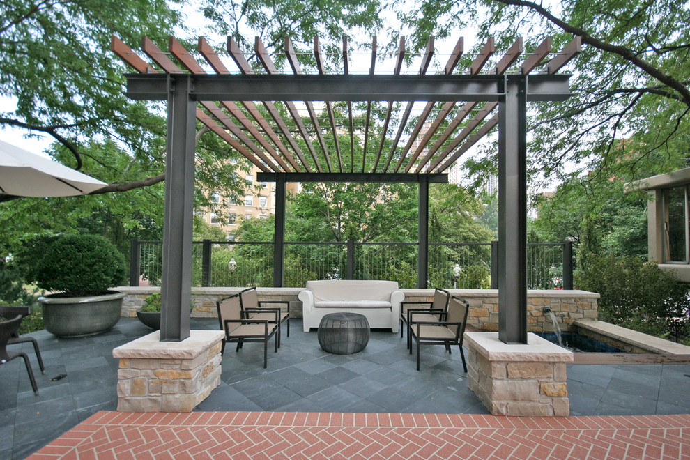 Example of a large trendy courtyard stone patio design in Chicago with a pergola