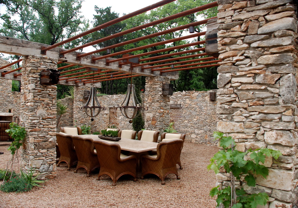 This is an example of a mediterranean patio in Austin with gravel and a pergola.