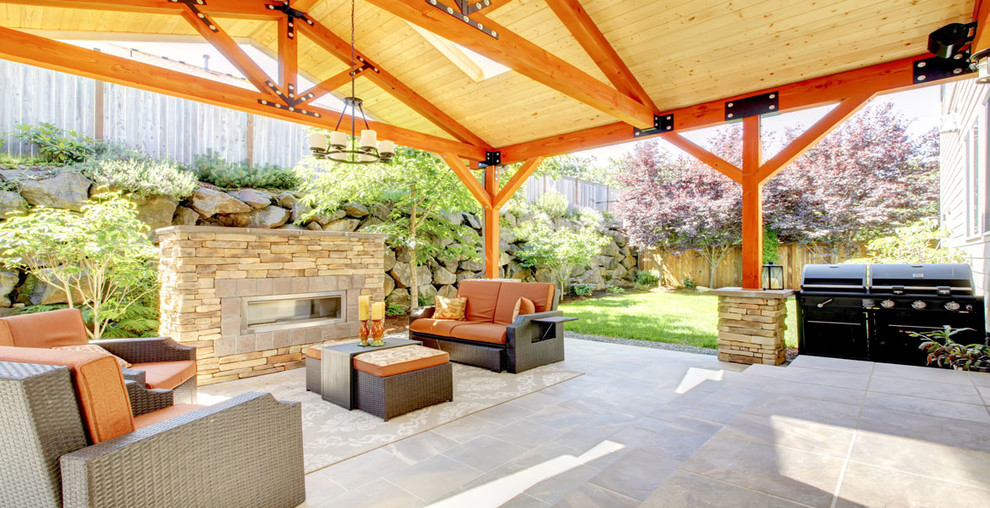 Esempio di un grande patio o portico minimal dietro casa con un focolare, pavimentazioni in pietra naturale e un gazebo o capanno