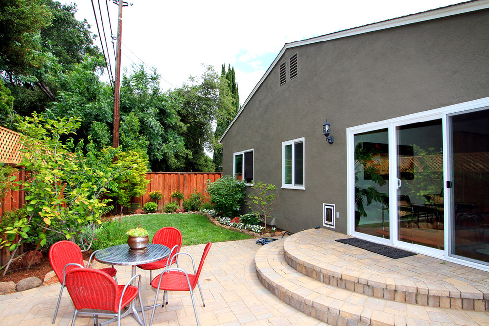Diseño de patio actual de tamaño medio sin cubierta en patio trasero con adoquines de ladrillo