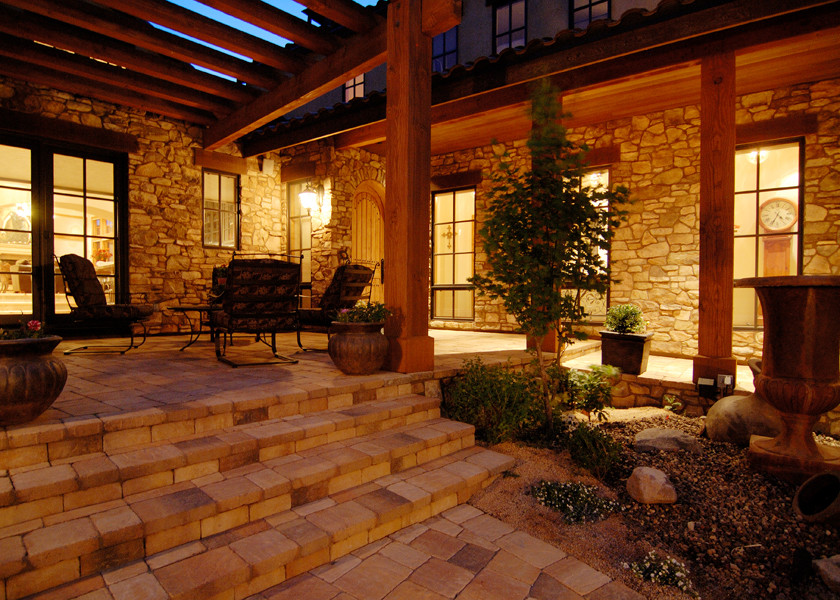 Immagine di un grande patio o portico chic in cortile con un giardino in vaso, pavimentazioni in pietra naturale e un tetto a sbalzo