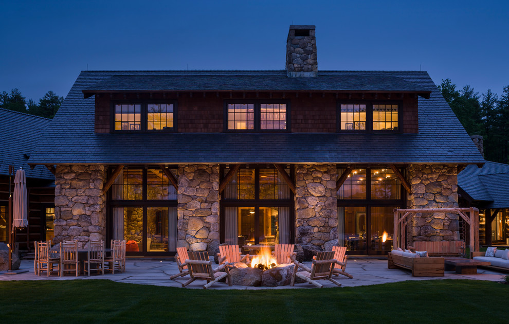 This is an example of a rustic back patio in New York with a fire feature and no cover.