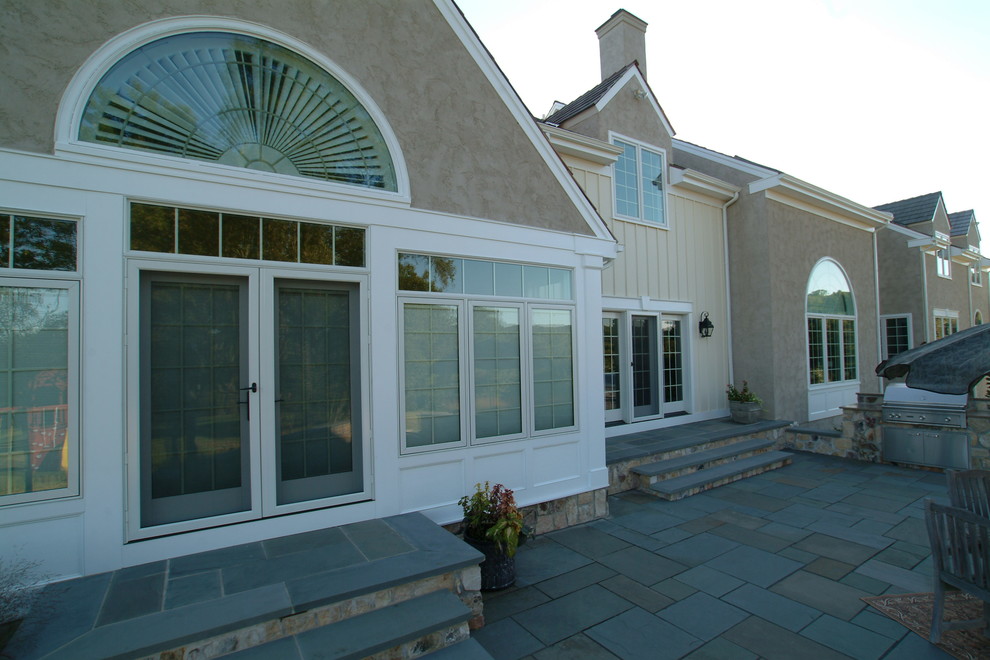 Esempio di un ampio patio o portico tradizionale dietro casa con pavimentazioni in pietra naturale