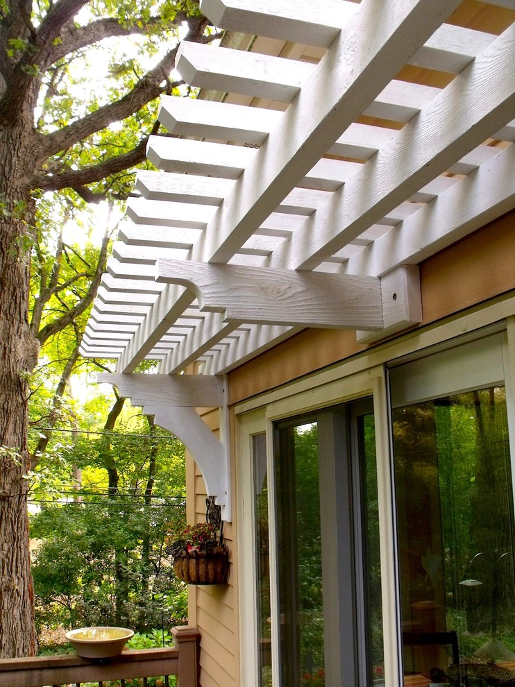 Esempio di un patio o portico american style di medie dimensioni e dietro casa con pavimentazioni in pietra naturale e una pergola