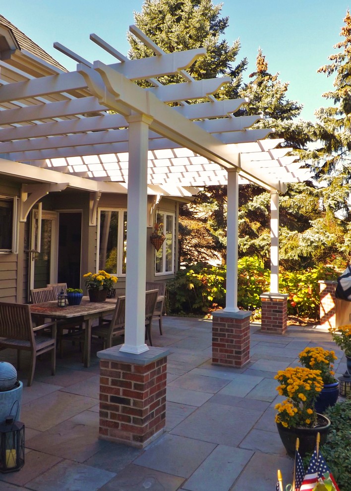 Example of a mid-sized arts and crafts backyard stone patio design in Chicago with a pergola