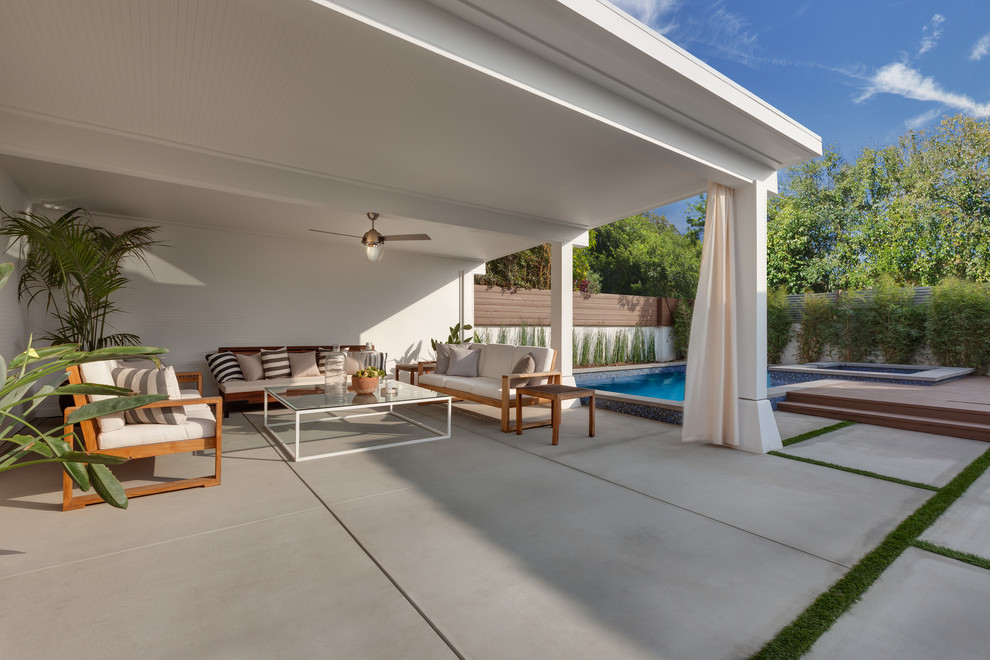 Exemple d'une terrasse arrière tendance de taille moyenne avec une dalle de béton et un gazebo ou pavillon.