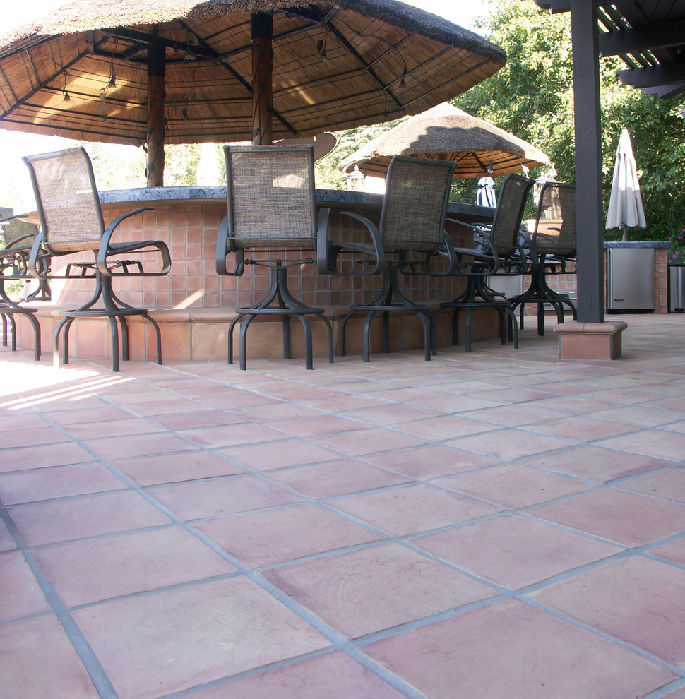 Modelo de patio mediterráneo grande en patio trasero con suelo de baldosas, cocina exterior y cenador