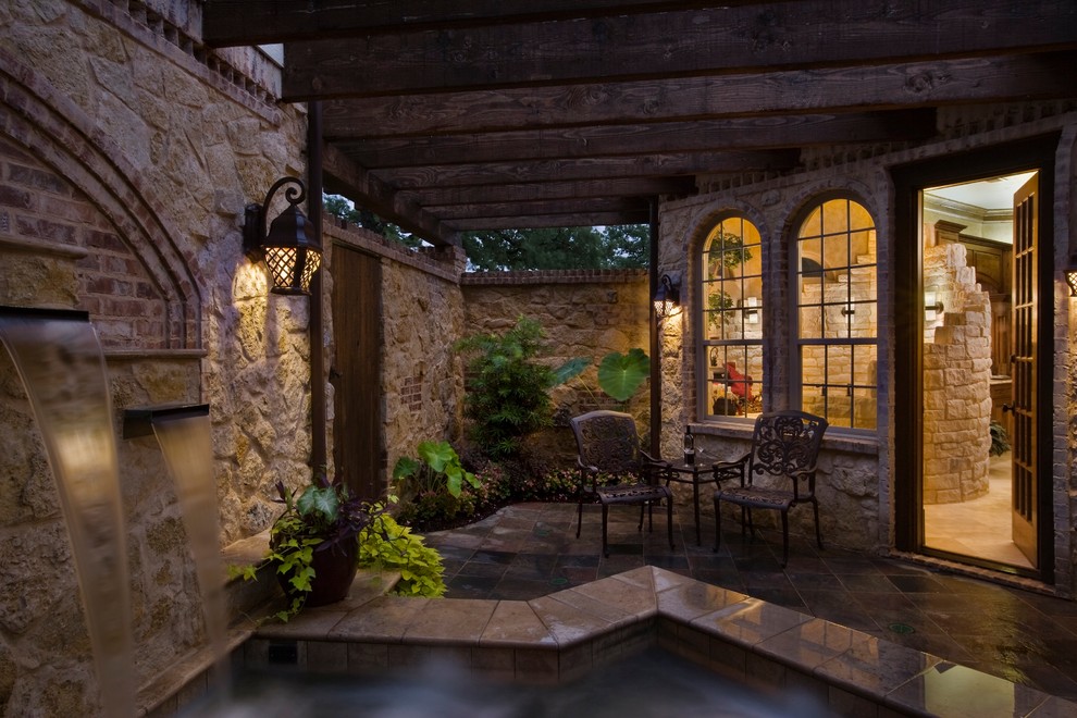 Стильный дизайн: двор на внутреннем дворе в стиле рустика с фонтаном, покрытием из плитки и навесом - последний тренд