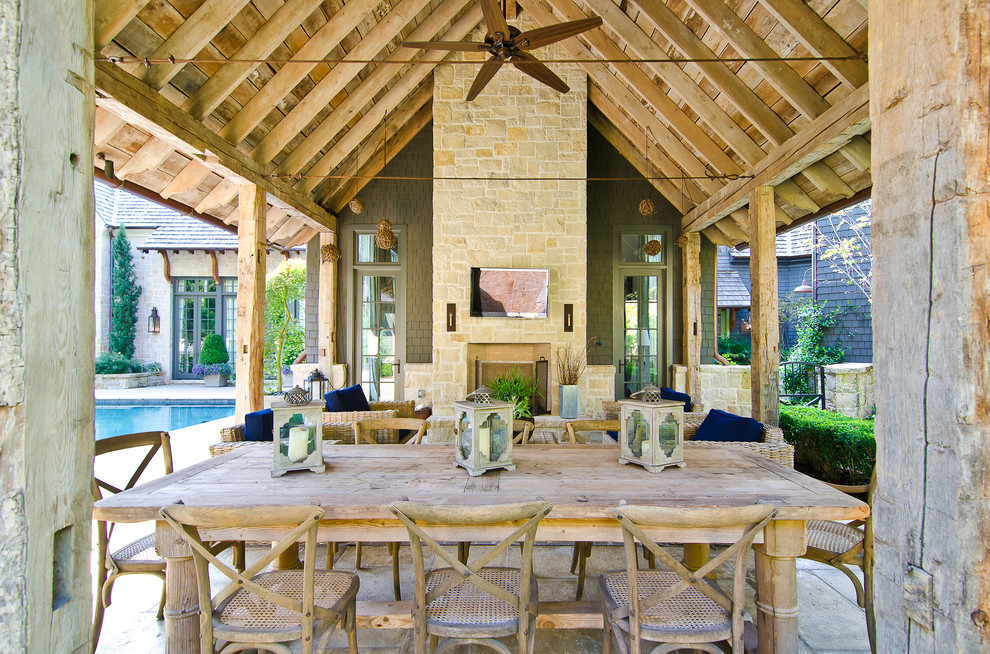 Cette image montre une terrasse traditionnelle avec un foyer extérieur et une extension de toiture.