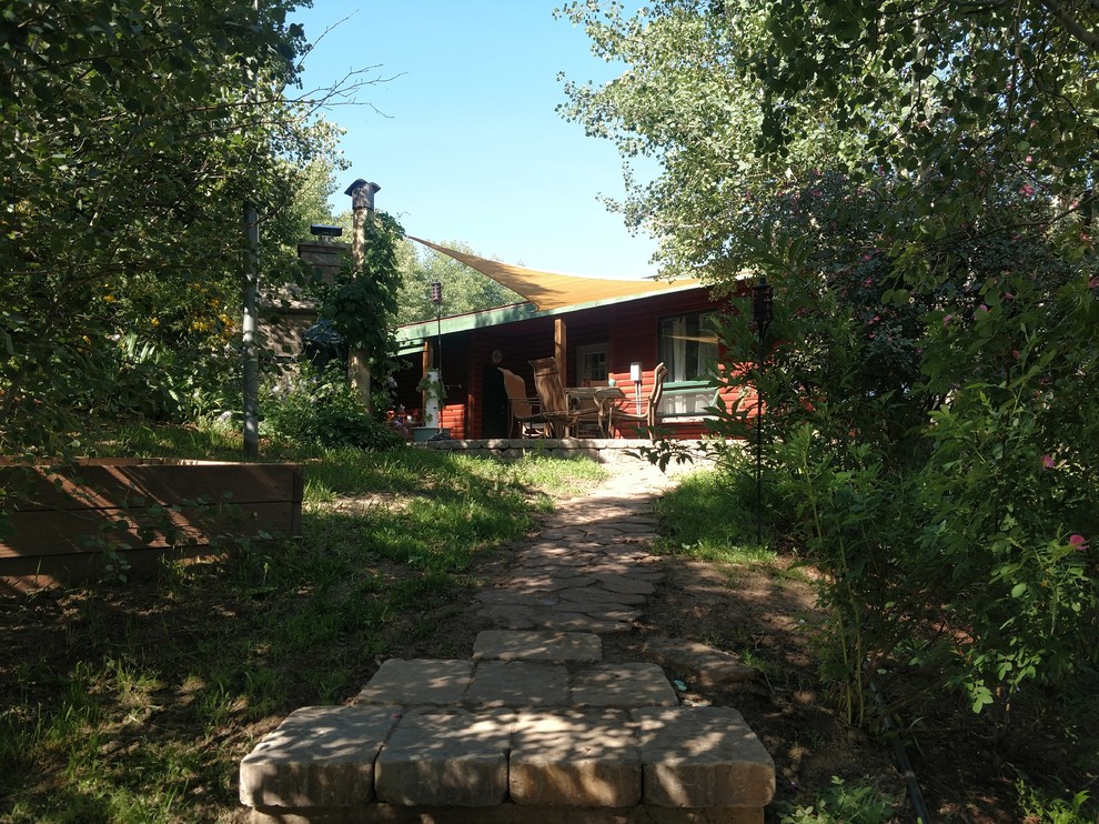 Mittelgroßer Rustikaler Patio hinter dem Haus mit Outdoor-Küche, Natursteinplatten und Markisen in Sonstige