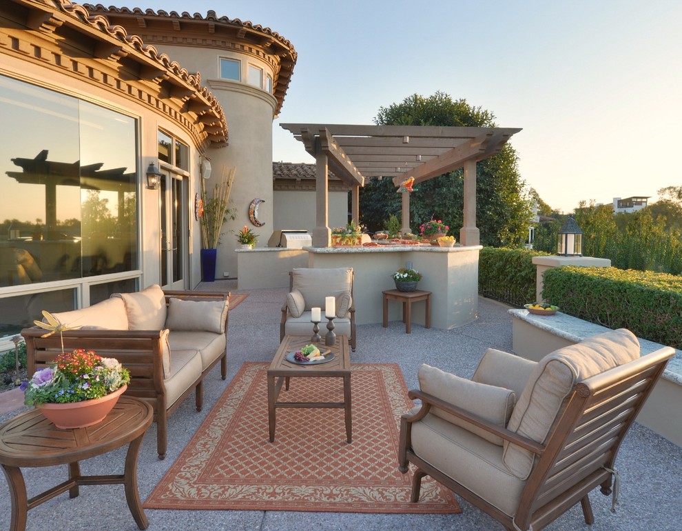 Imagen de patio clásico de tamaño medio en patio trasero con cocina exterior, pérgola y losas de hormigón