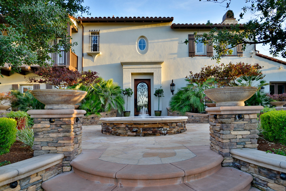 Immagine di un grande patio o portico mediterraneo davanti casa con fontane, pavimentazioni in pietra naturale e nessuna copertura