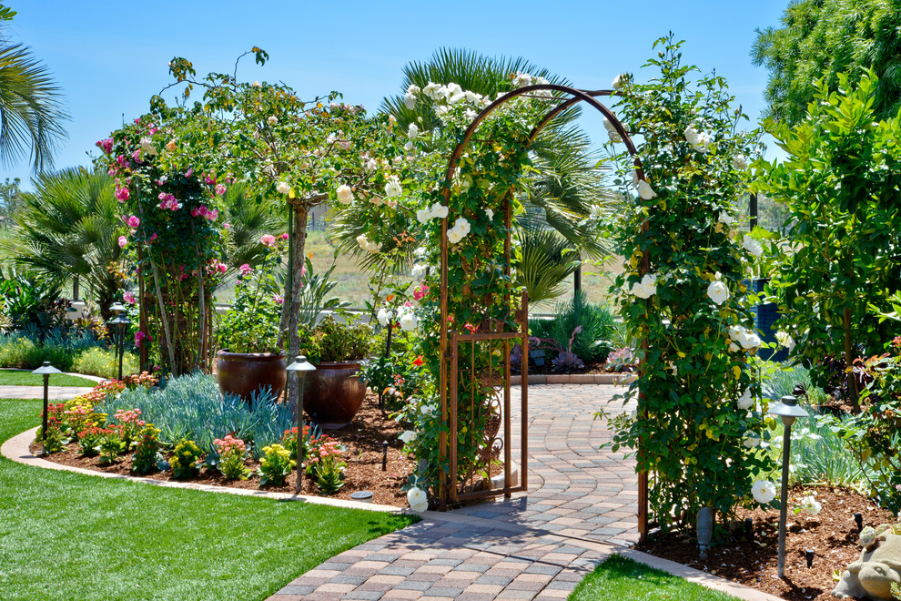 Ejemplo de patio mediterráneo grande en patio delantero con jardín de macetas, adoquines de hormigón y pérgola