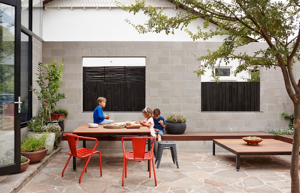 Immagine di un patio o portico minimal dietro casa con pavimentazioni in pietra naturale