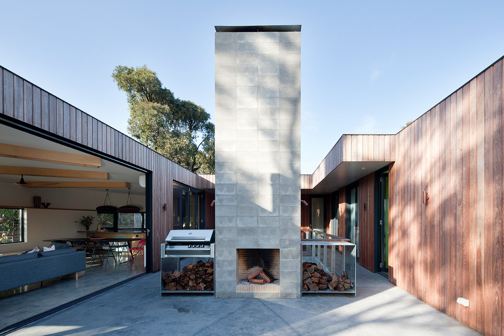 Пример оригинального дизайна: двор на внутреннем дворе в скандинавском стиле с уличным камином и покрытием из бетонных плит без защиты от солнца