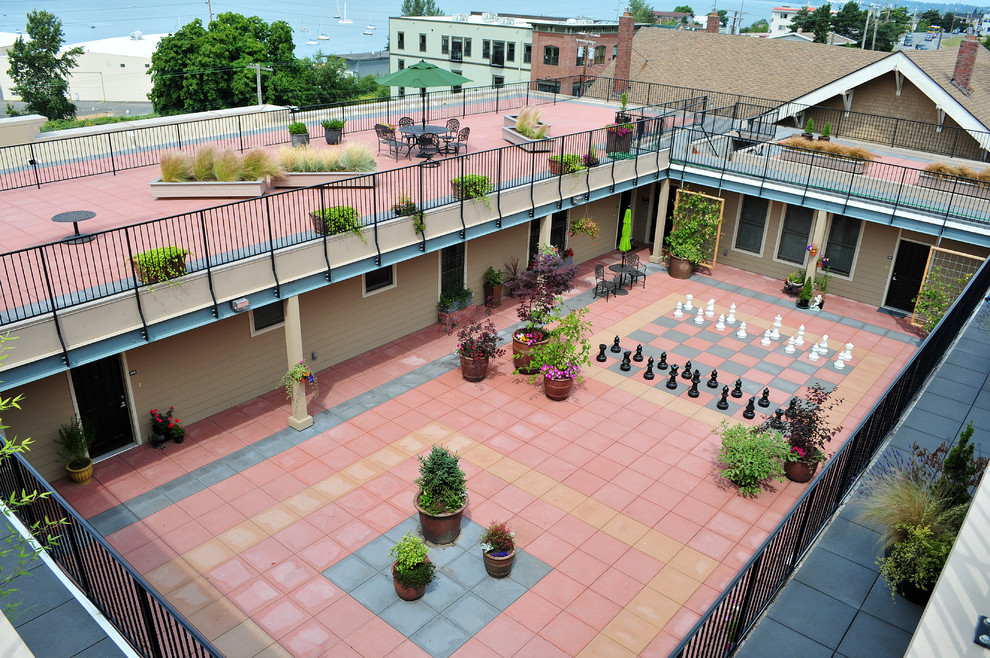 Aménagement d'une terrasse classique avec une cour, des pavés en béton et une extension de toiture.
