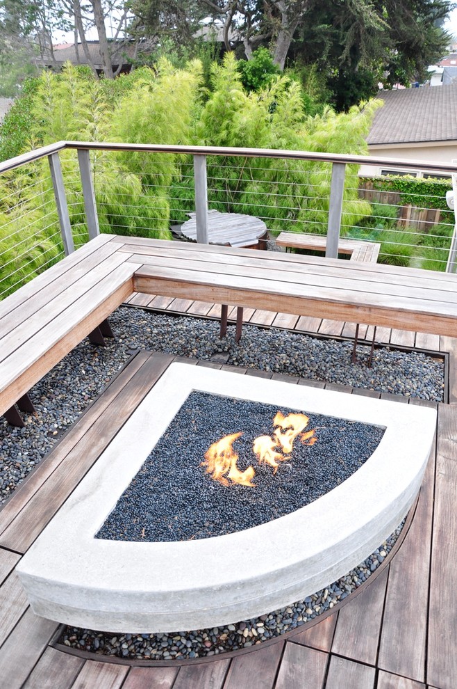 Cette photo montre une terrasse en bois tendance avec un foyer extérieur.