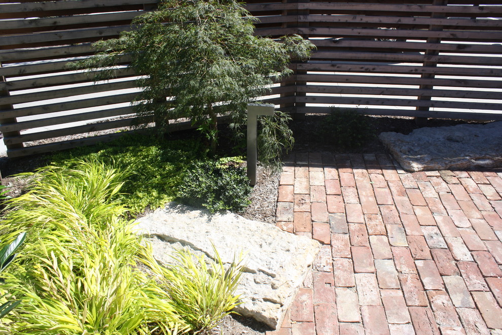 Réalisation d'une petite terrasse design avec une cour et des pavés en brique.