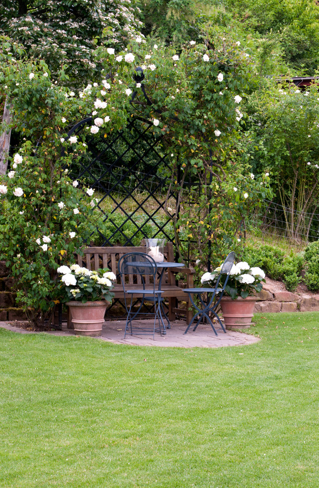 Ejemplo de patio campestre pequeño sin cubierta en patio lateral con adoquines de piedra natural y jardín vertical