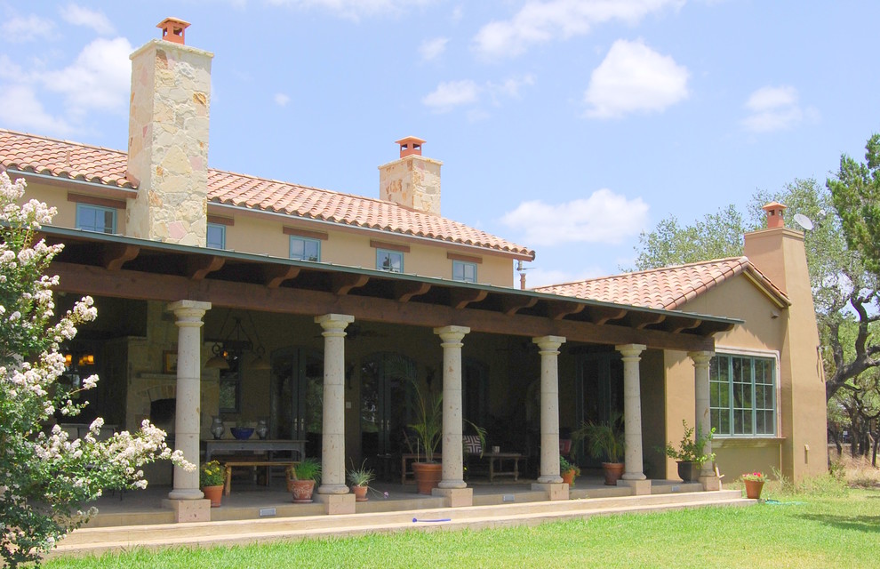 На фото: большой двор на заднем дворе в средиземноморском стиле с покрытием из бетонных плит и навесом с