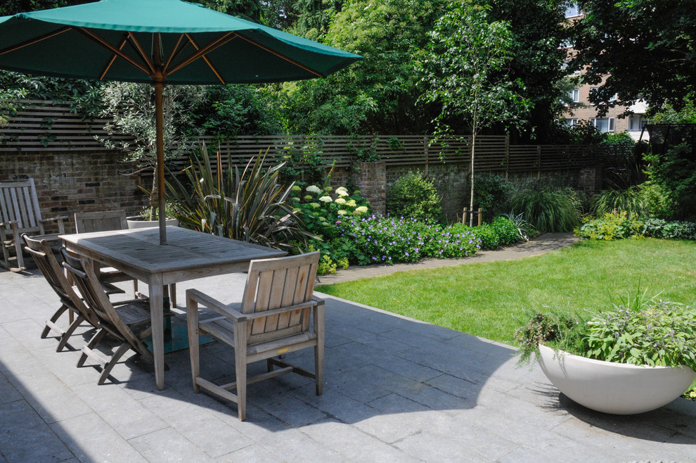 Inspiration for a mid-sized timeless backyard concrete patio remodel in London