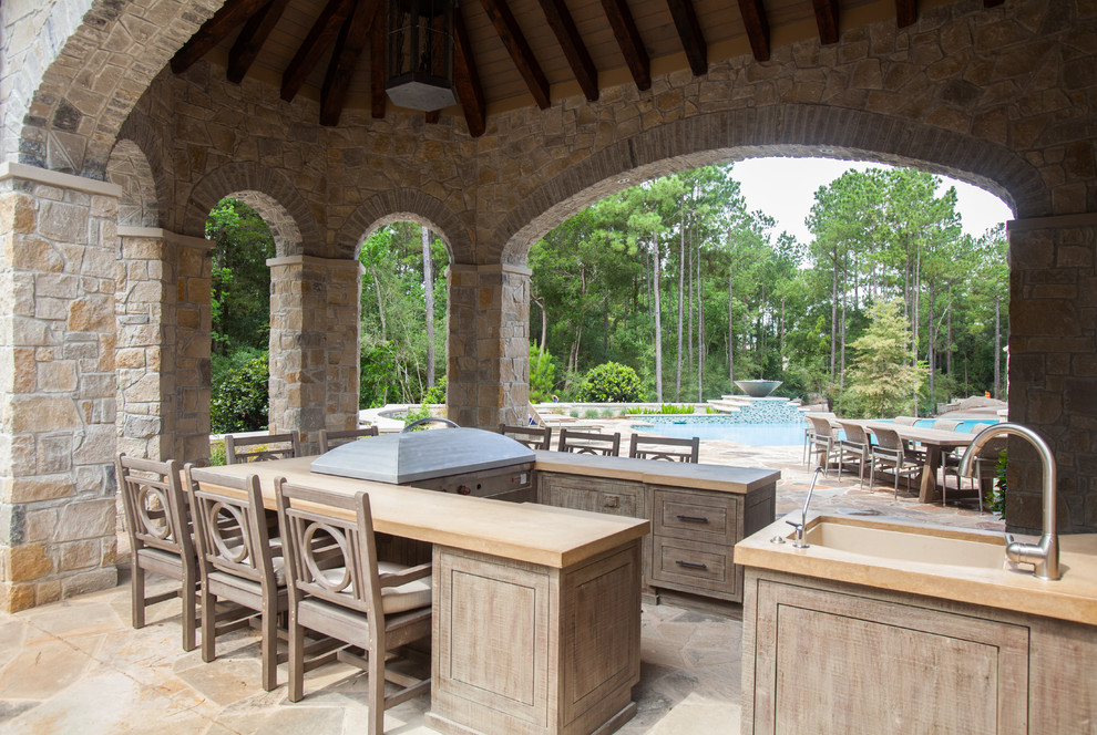 Mittelgroßer, Überdachter Klassischer Patio hinter dem Haus mit Outdoor-Küche und Natursteinplatten in Houston