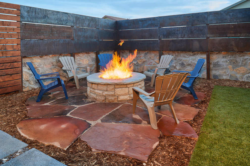 Trendy backyard stone patio photo in Other with a fire pit and no cover