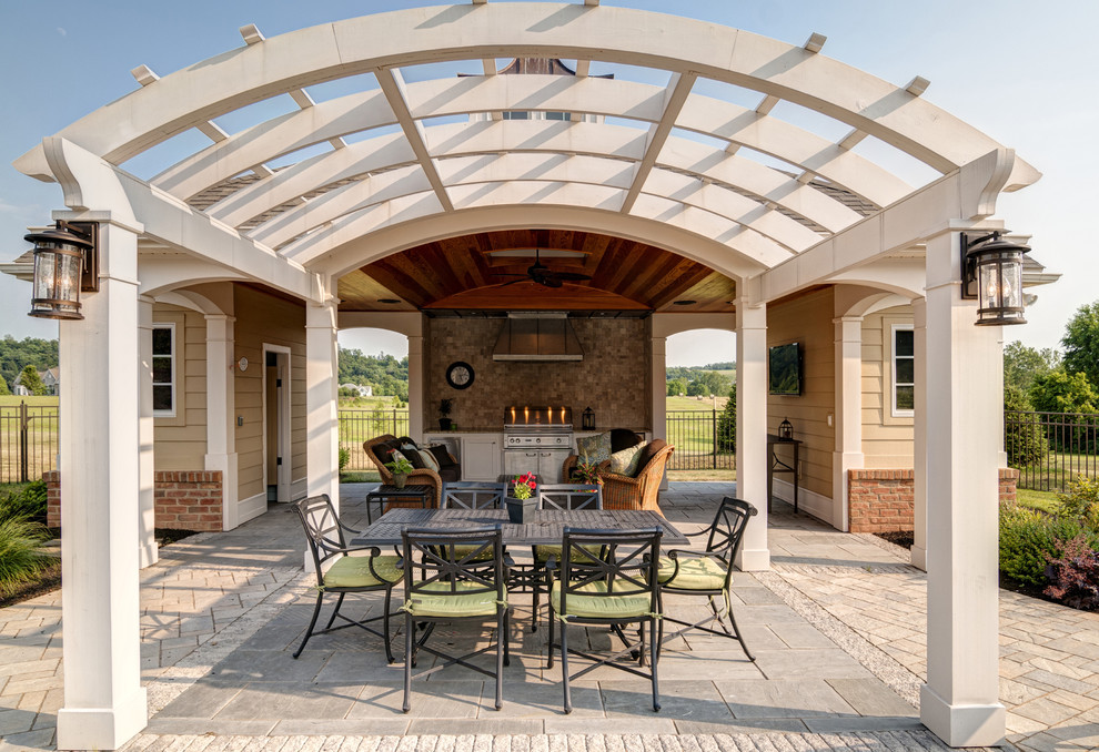 Elegant patio kitchen photo in Other with a pergola