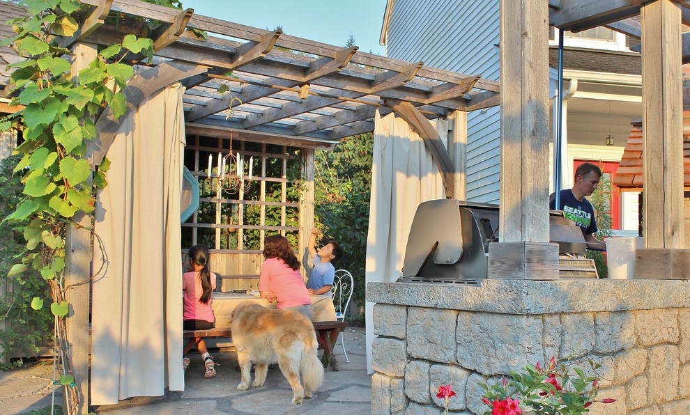 Réalisation d'une grande terrasse arrière champêtre avec une cuisine d'été et du béton estampé.