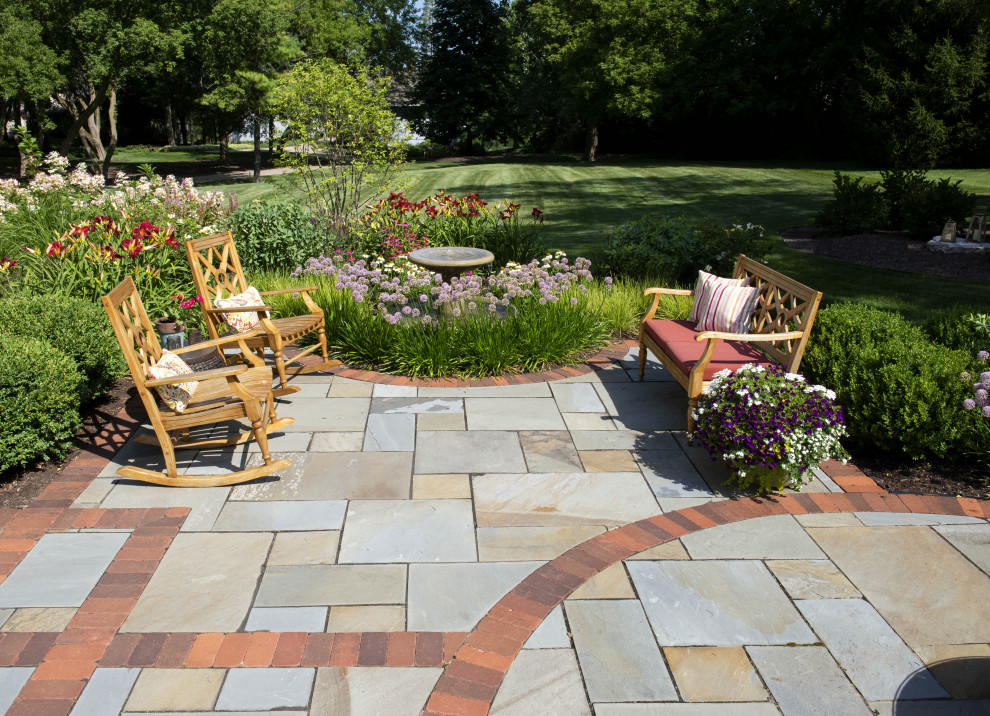 Diseño de patio clásico grande en patio trasero con fuente y adoquines de piedra natural