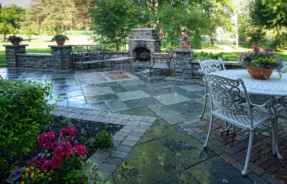 Example of a farmhouse backyard concrete paver patio design in Toronto with a fire pit