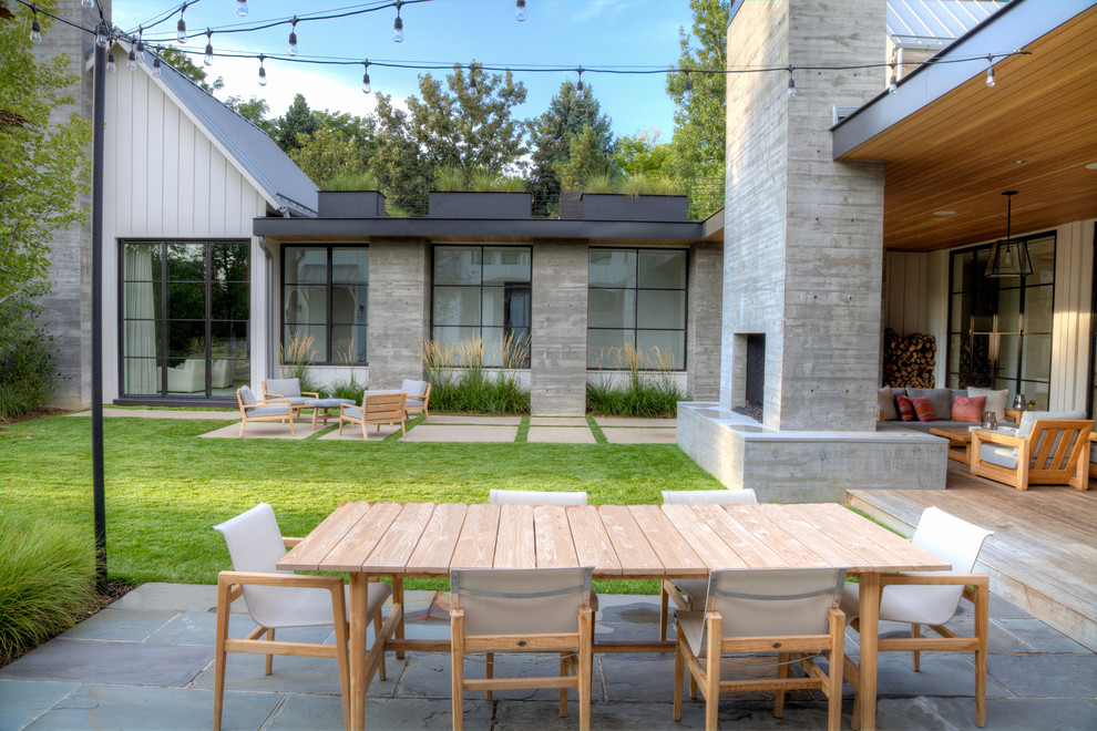 This is an example of a contemporary patio in Denver with a roof extension and a fireplace.