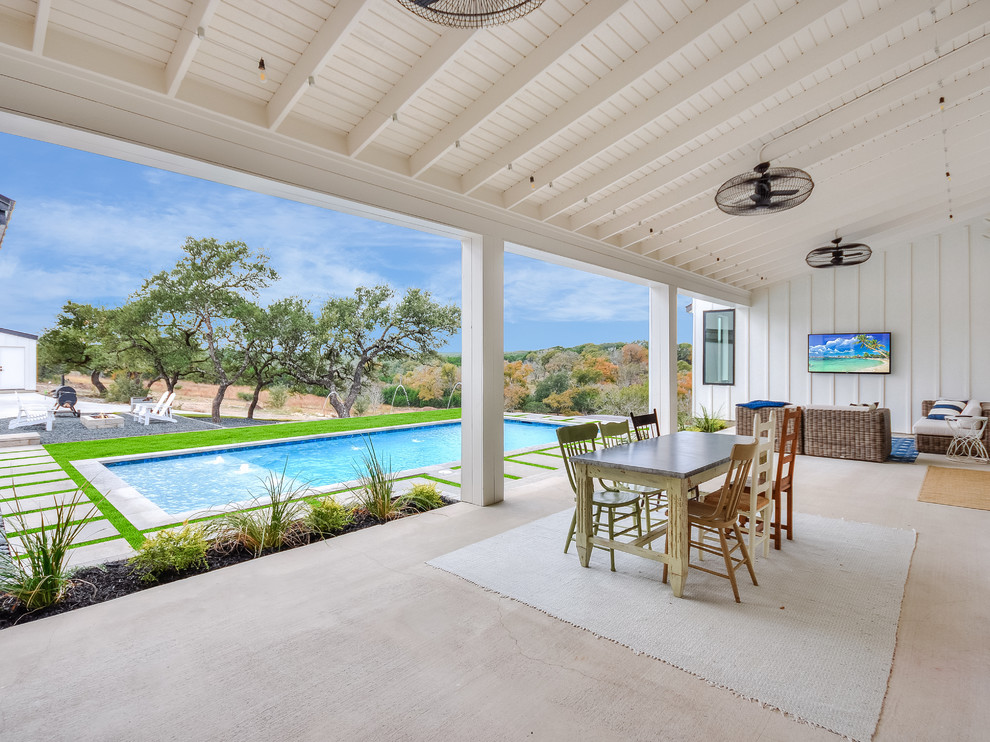 Large cottage backyard concrete patio photo in Austin with a fire pit and a roof extension
