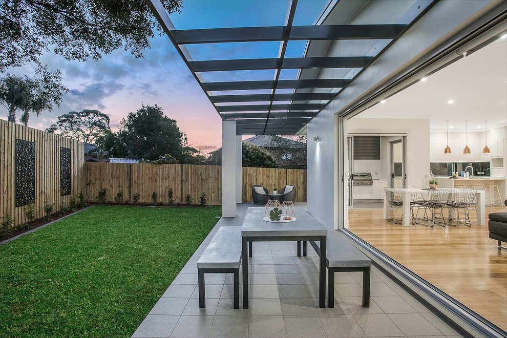 Modelo de patio contemporáneo con adoquines de hormigón y pérgola