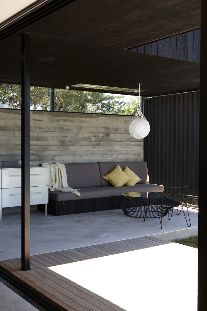 Réalisation d'une terrasse design avec une dalle de béton et une extension de toiture.