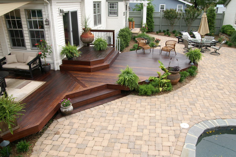 This is an example of a large traditional back patio in DC Metro with decking and an awning.
