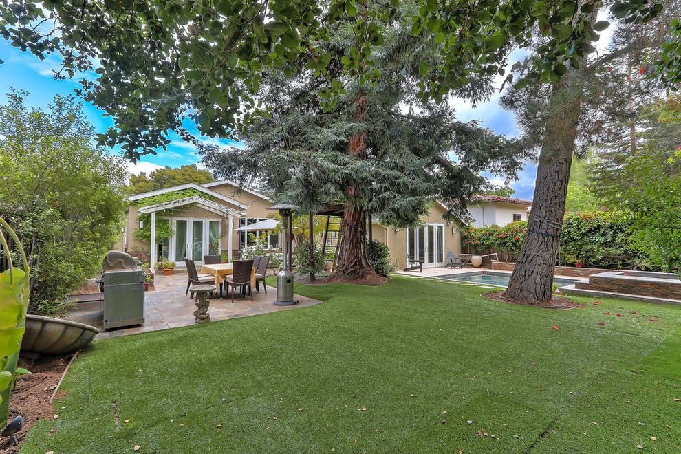 Foto di un ampio patio o portico moderno dietro casa con pavimentazioni in pietra naturale