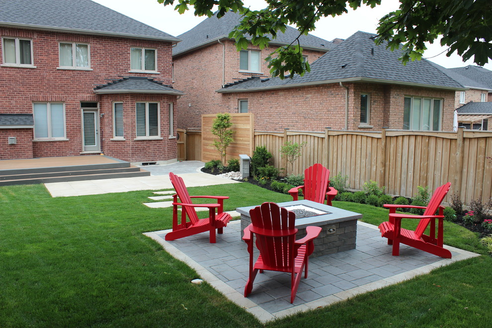 Inspiration for a large timeless backyard concrete paver patio remodel in Toronto with a fire pit