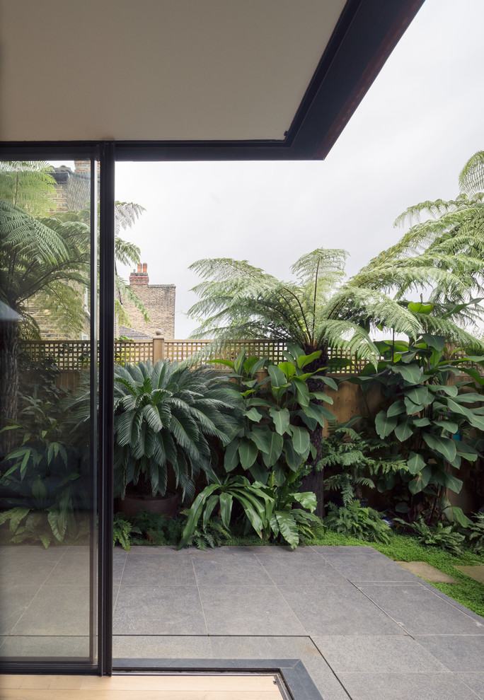 Foto di un patio o portico minimal di medie dimensioni e dietro casa con pavimentazioni in pietra naturale