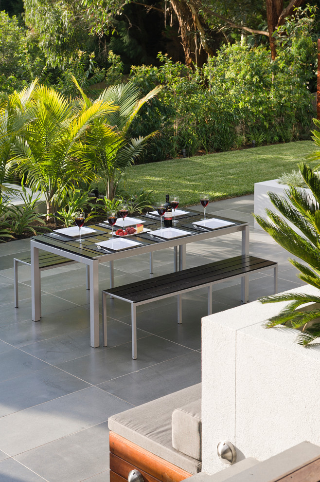 Réalisation d'une terrasse arrière design avec une cuisine d'été et un gazebo ou pavillon.