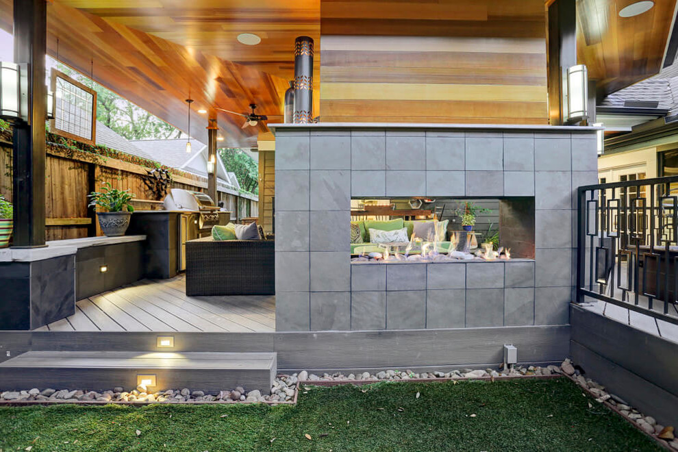 Esempio di un patio o portico eclettico di medie dimensioni con un focolare, pedane e un tetto a sbalzo