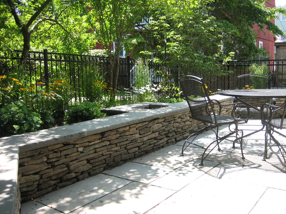 Modelo de patio contemporáneo en patio trasero con adoquines de piedra natural