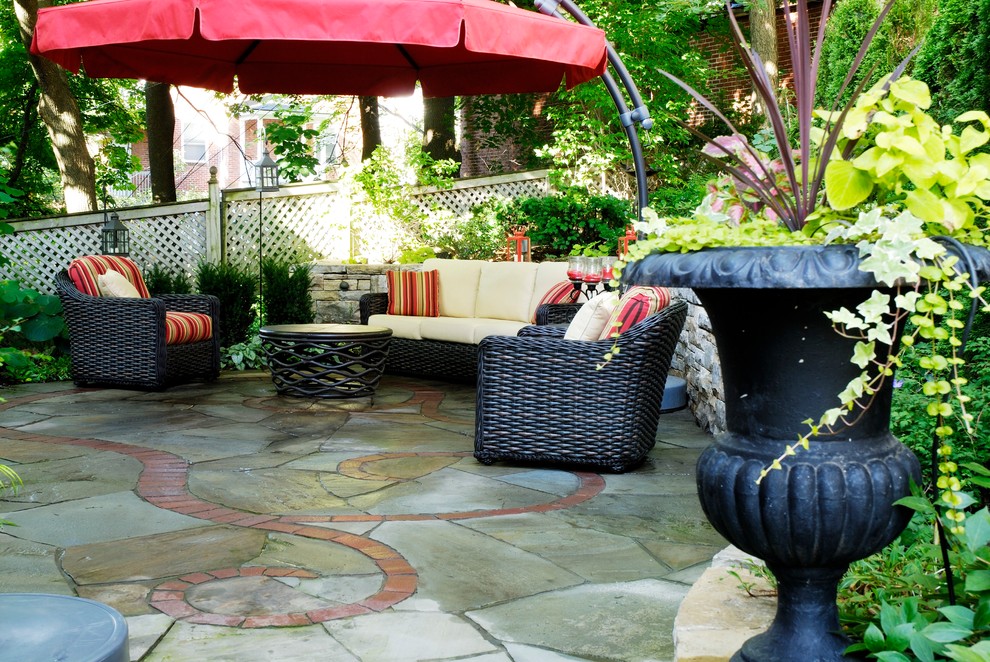 Photo of a small bohemian back patio in Montreal with natural stone paving and an awning.